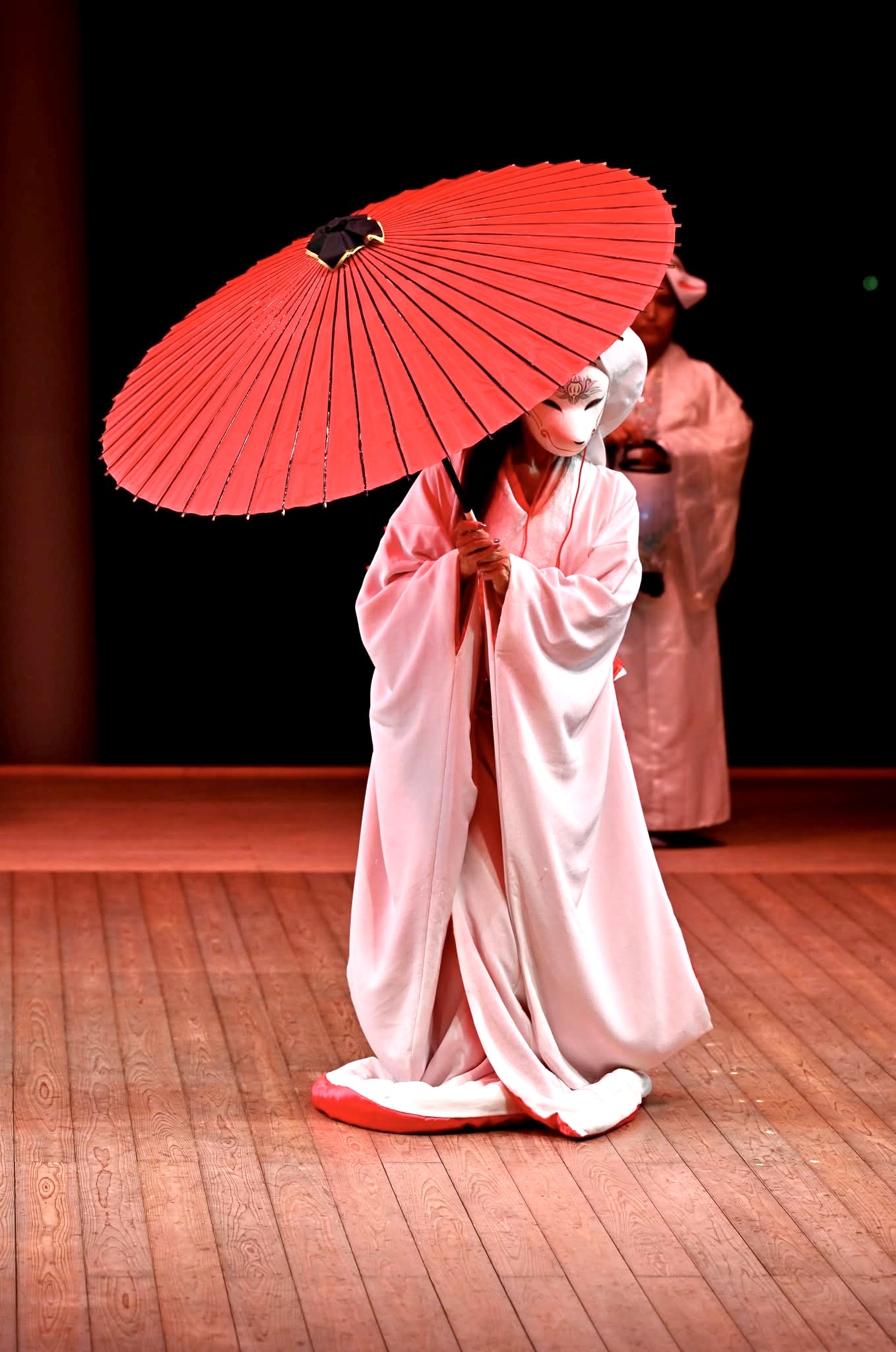 赤い和傘を差して舞う出演者