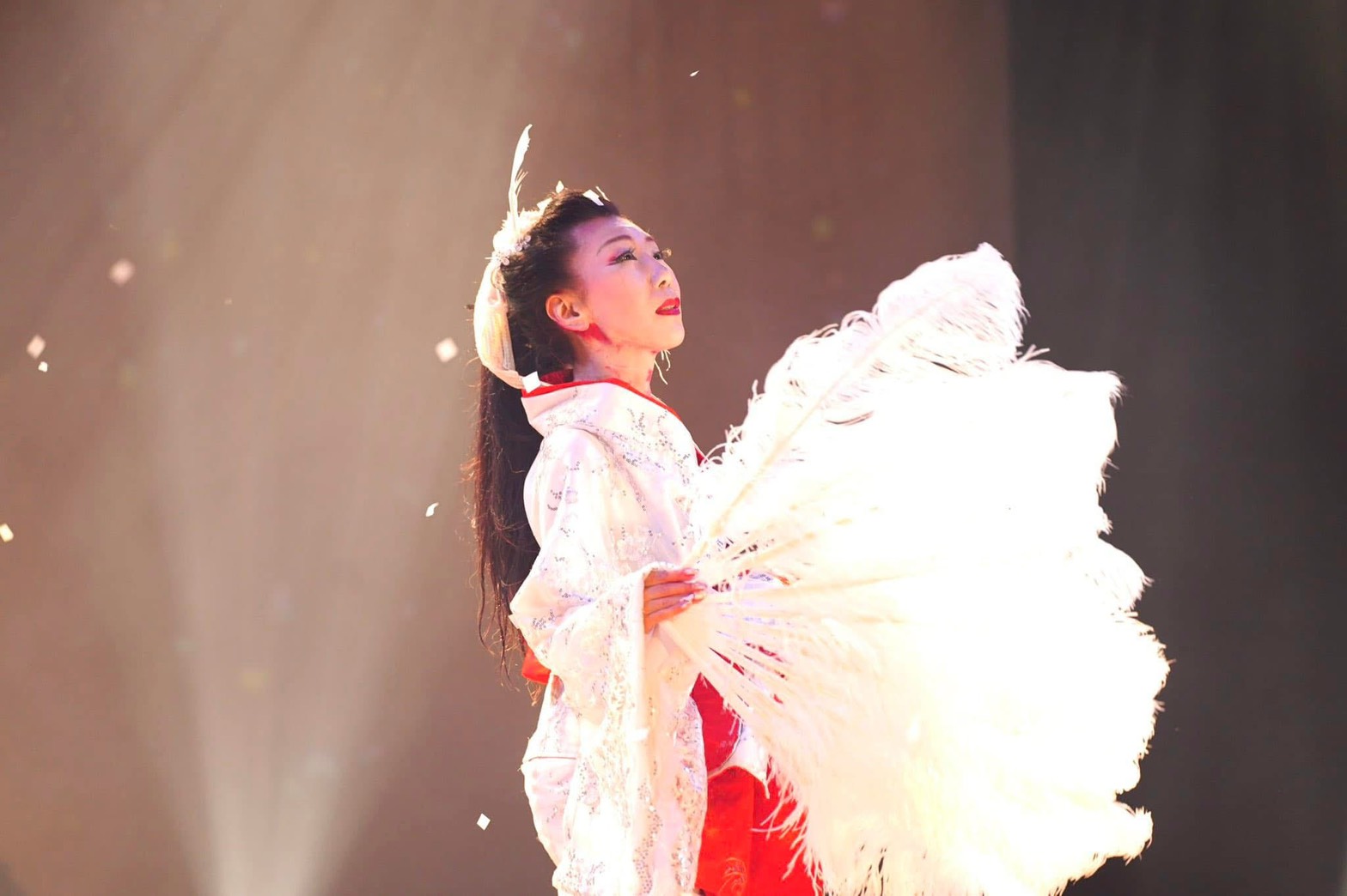 白い衣裳で大きな羽根扇を手に舞う飯干未奈